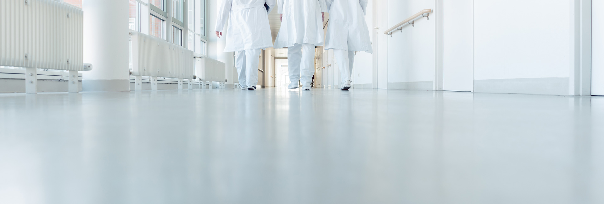 Doctors Walk Down Hospital Corridor